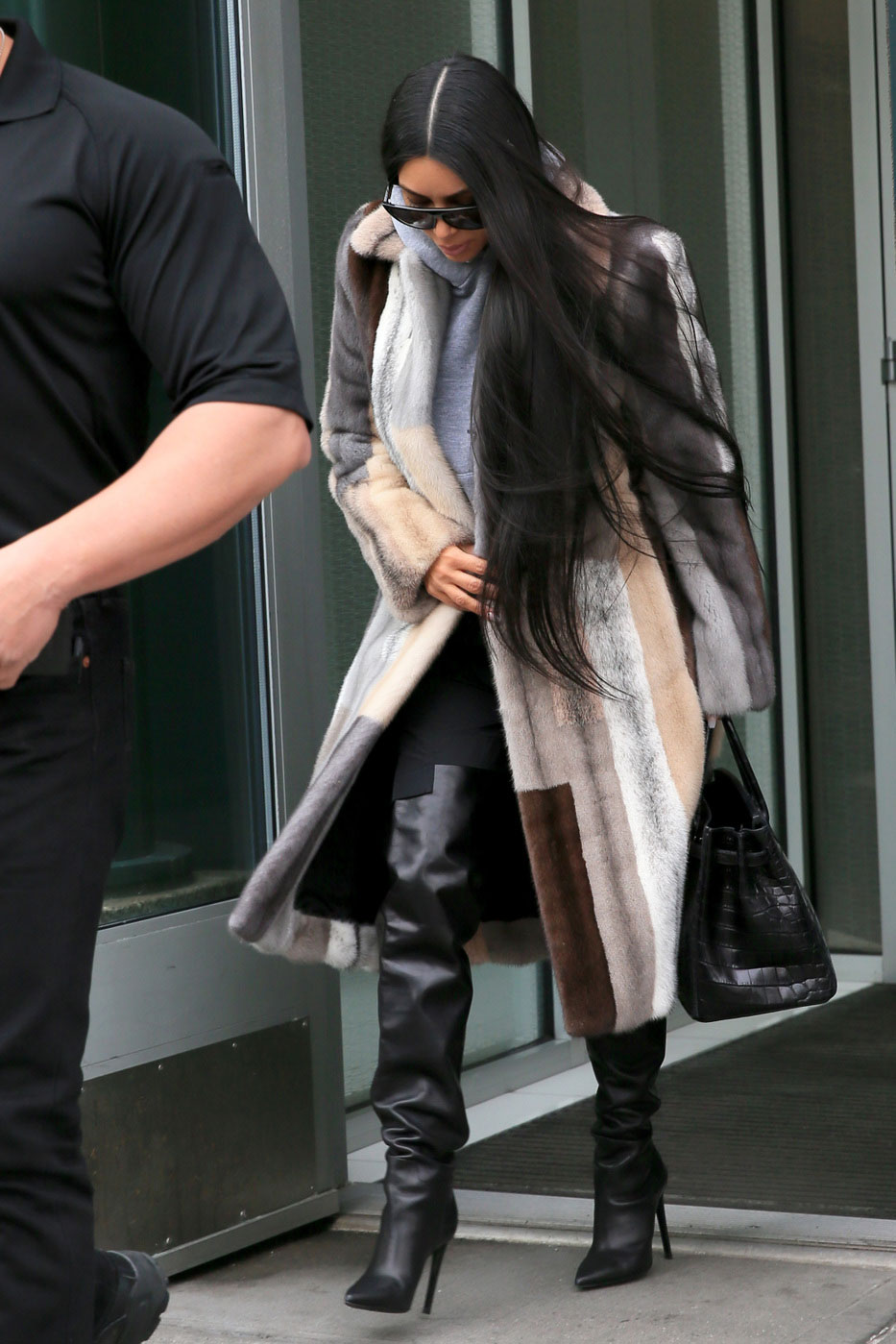 Shop Kim Kardashian's multi-color fur coat, hooded sweatshirt and over-the-knee boots look for less.