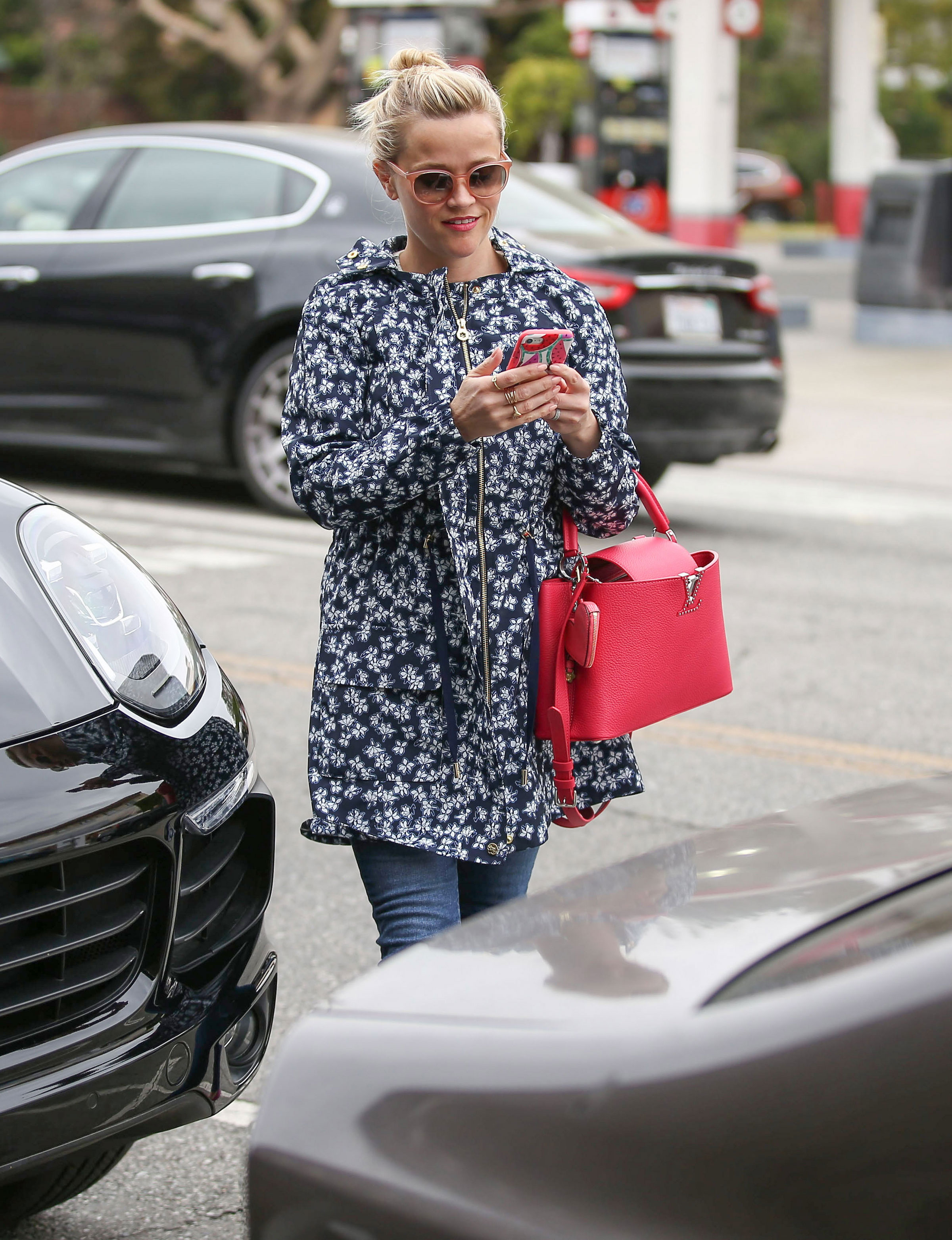 Reese Witherspoon stays stylish in the rain in a floral Draper James jacket.