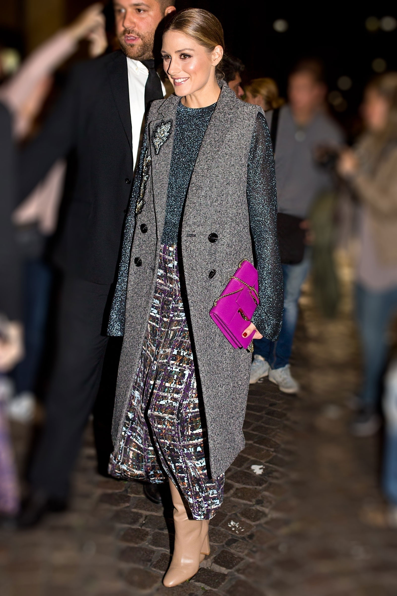 Olivia Palermo wears a sleeveless coat and beige boots at the Ferragamo show in Milan.