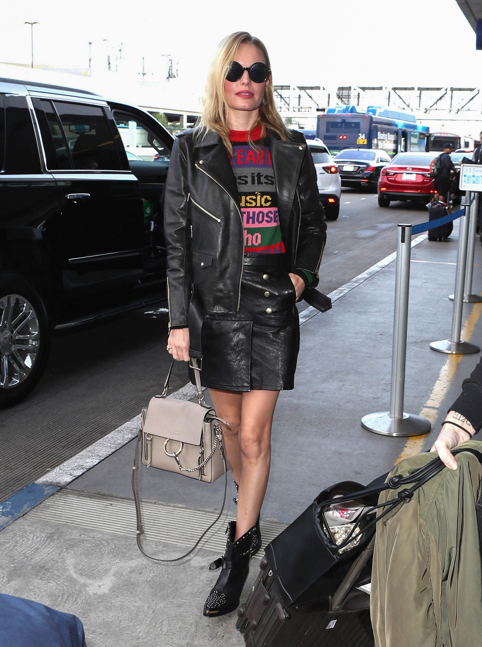 Kate Bosworth wears Etro's colorblock graphic sweater with an Anine Bing biker jacket, Frame leather mini skirt and moto boots.
