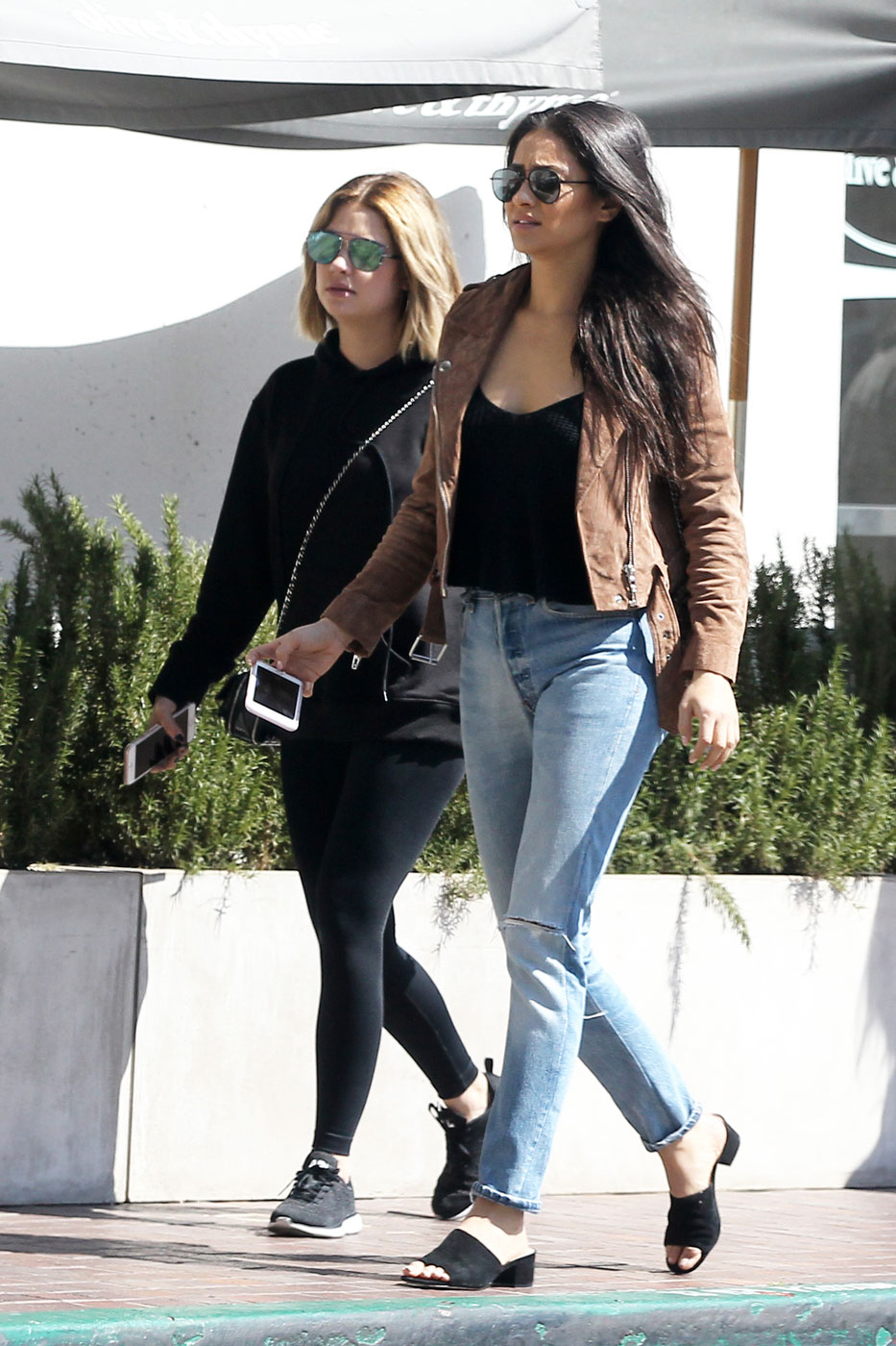 Shay Mitchell shows off her casual style in a tan moto jacket and black mules.