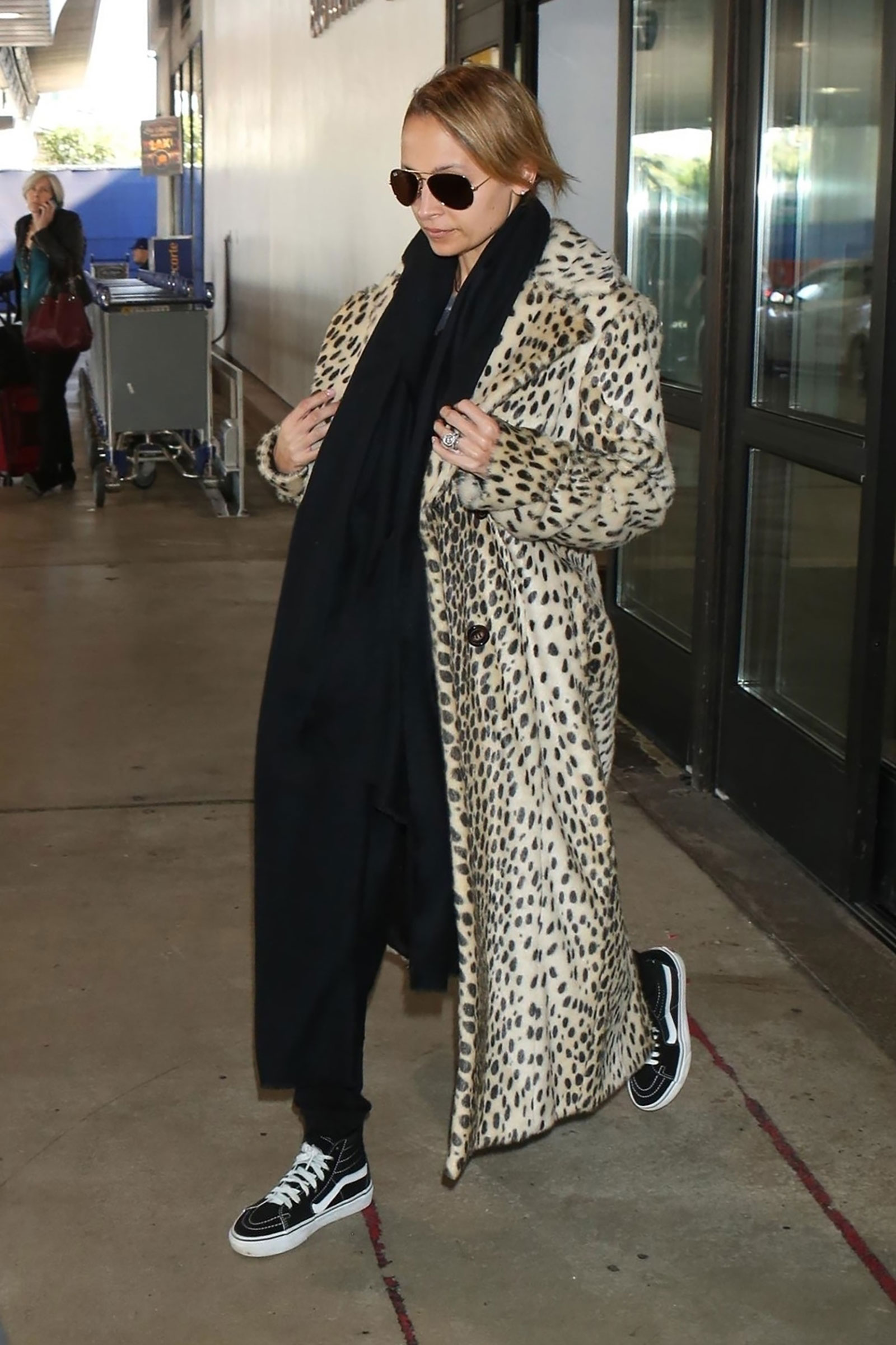 Nicole Richie wears a leopard coat with Vans sneakers for travel