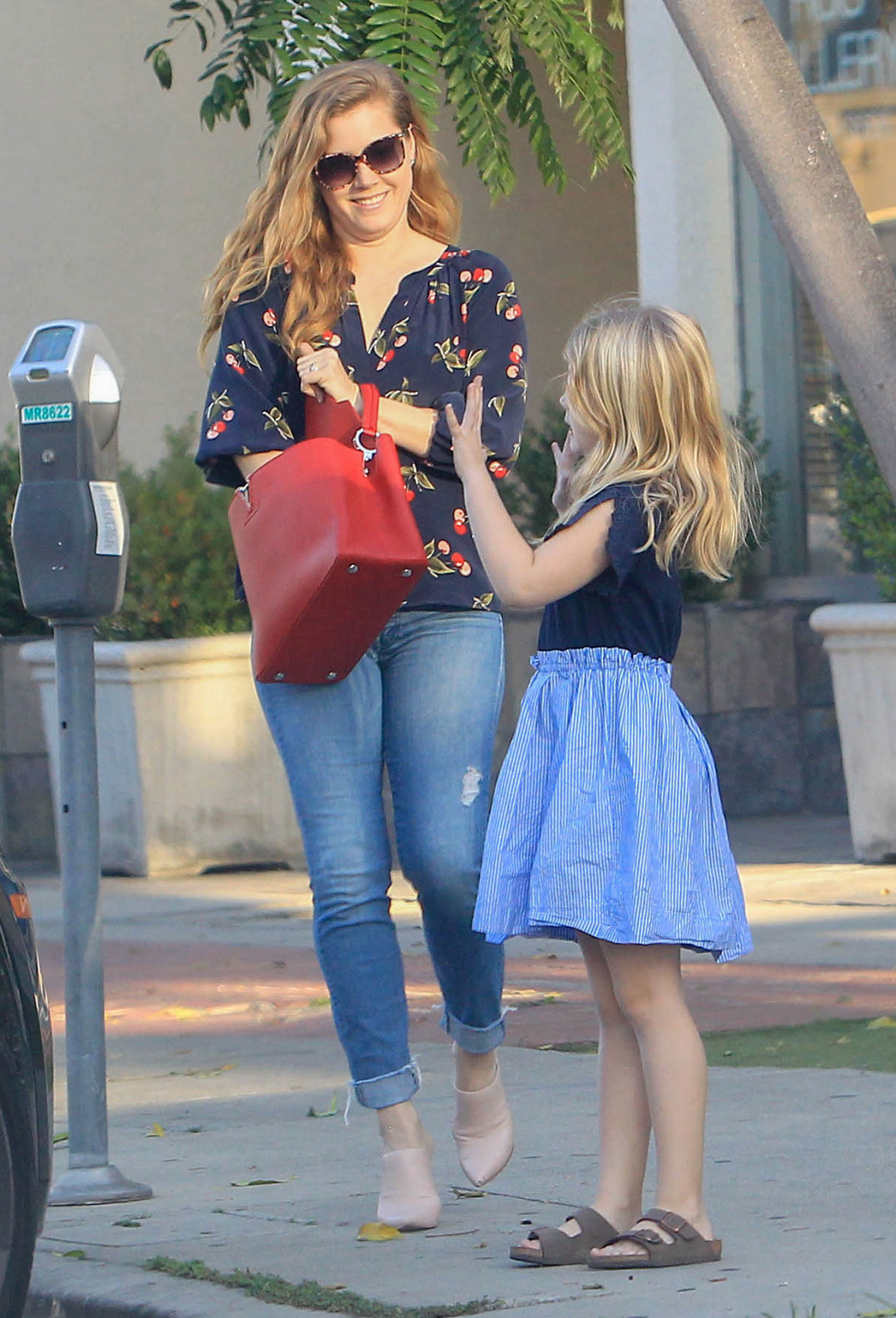Amy Adams' wears a Joie cherry print blouse with jeans and nude mule heels.