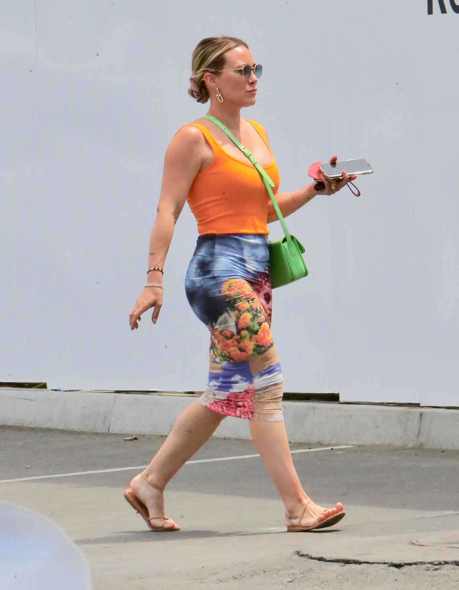 Hilary Duff in an orange tank and colorful multicolor painterly pencil skirt.